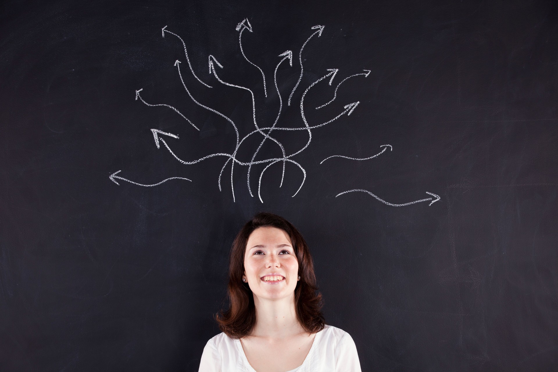 a woman standing in front of a blackboard with arrows drawn on it